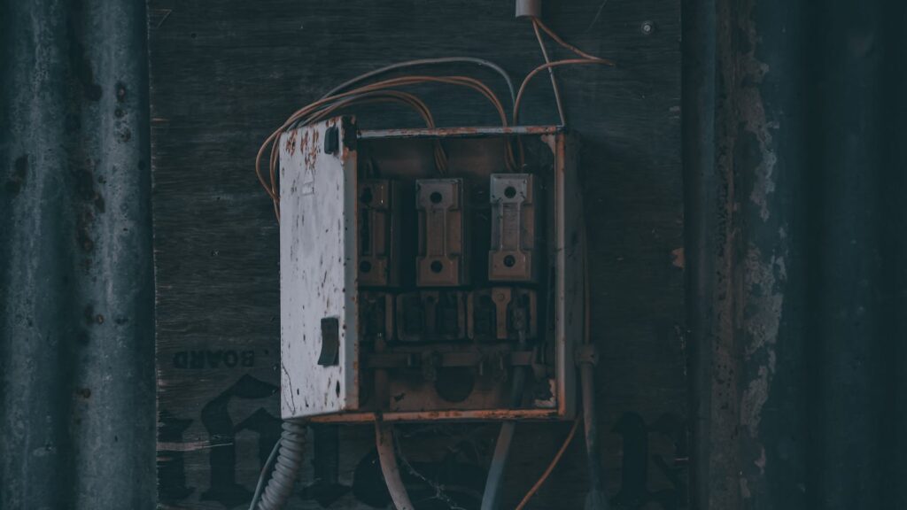A worn, rusty electrical panel with visible wiring, illustrating signs a panel needs upgrading