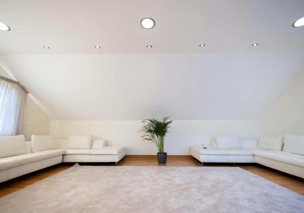 Row of recessed can lights installed in a residential living room ceiling